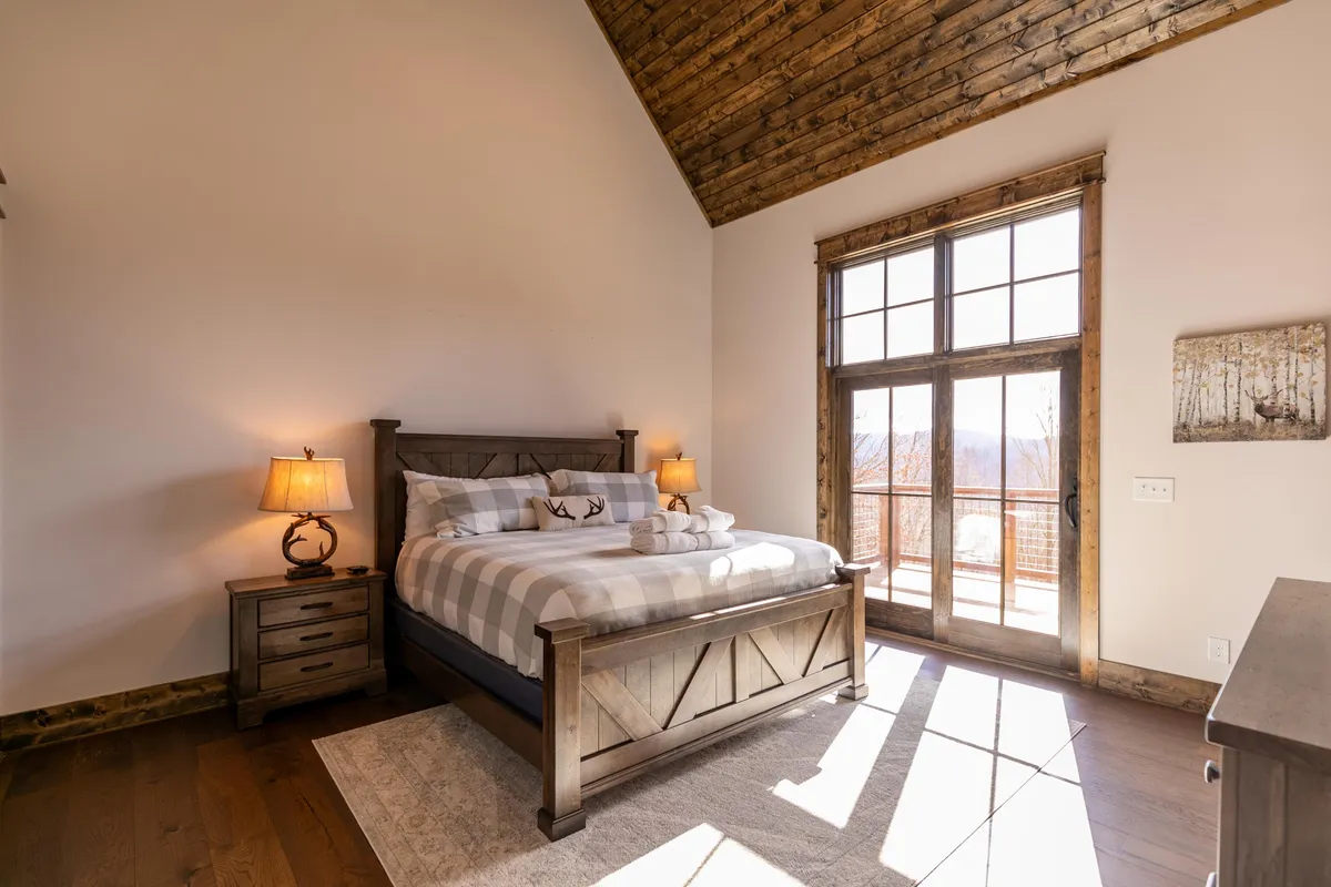 A serene bedroom featuring a plush bed, soft lighting from bedside lamps, and windows that let in gentle natural light, creating a tranquil atmosphere ideal for rest and relaxation.