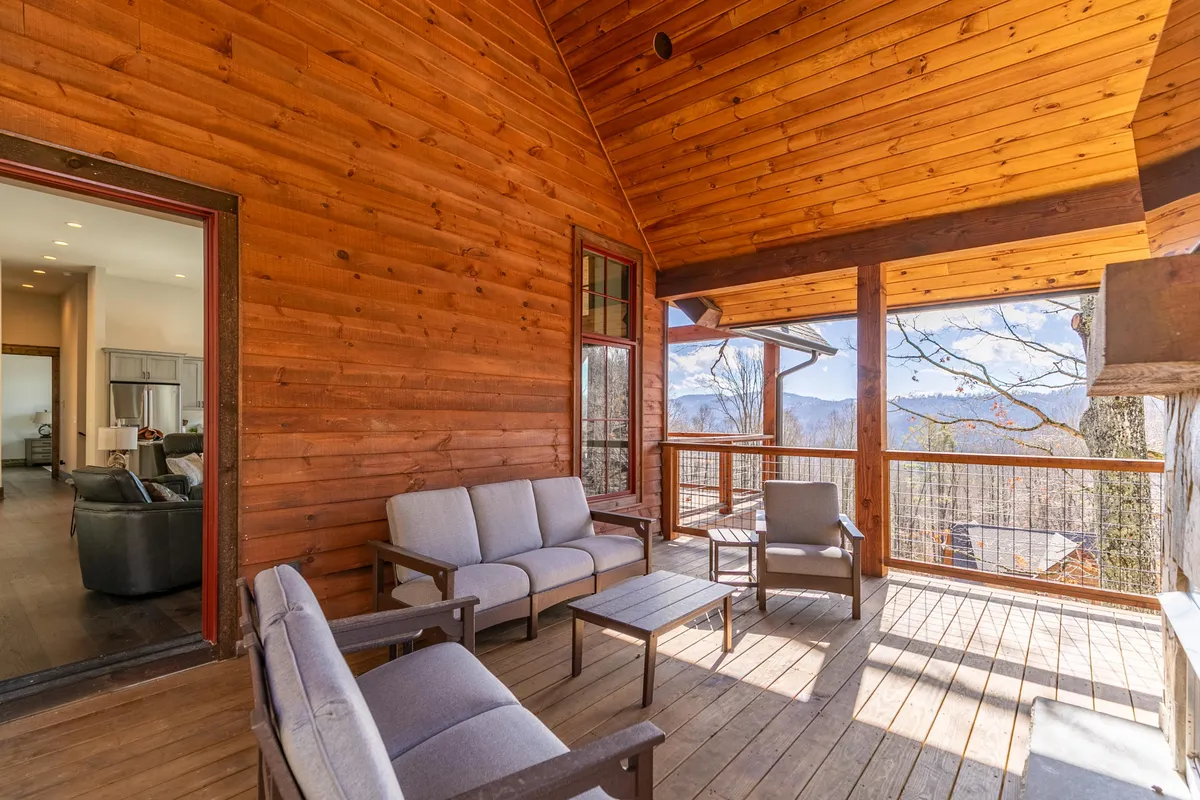 A tranquil segment of the deck showcases plush seating arranged for relaxation, overlooking a sunrise or sunset across the mountains. The environment is peaceful, with nature taking center stage, and ample space for quiet reflection or socializing.