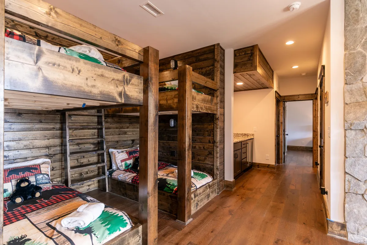 A playful bunk nook with built-in wooden bunks and soft textiles, inviting children or extra guests to enjoy cozy sleepovers or storytelling sessions in a warm, playful setting.